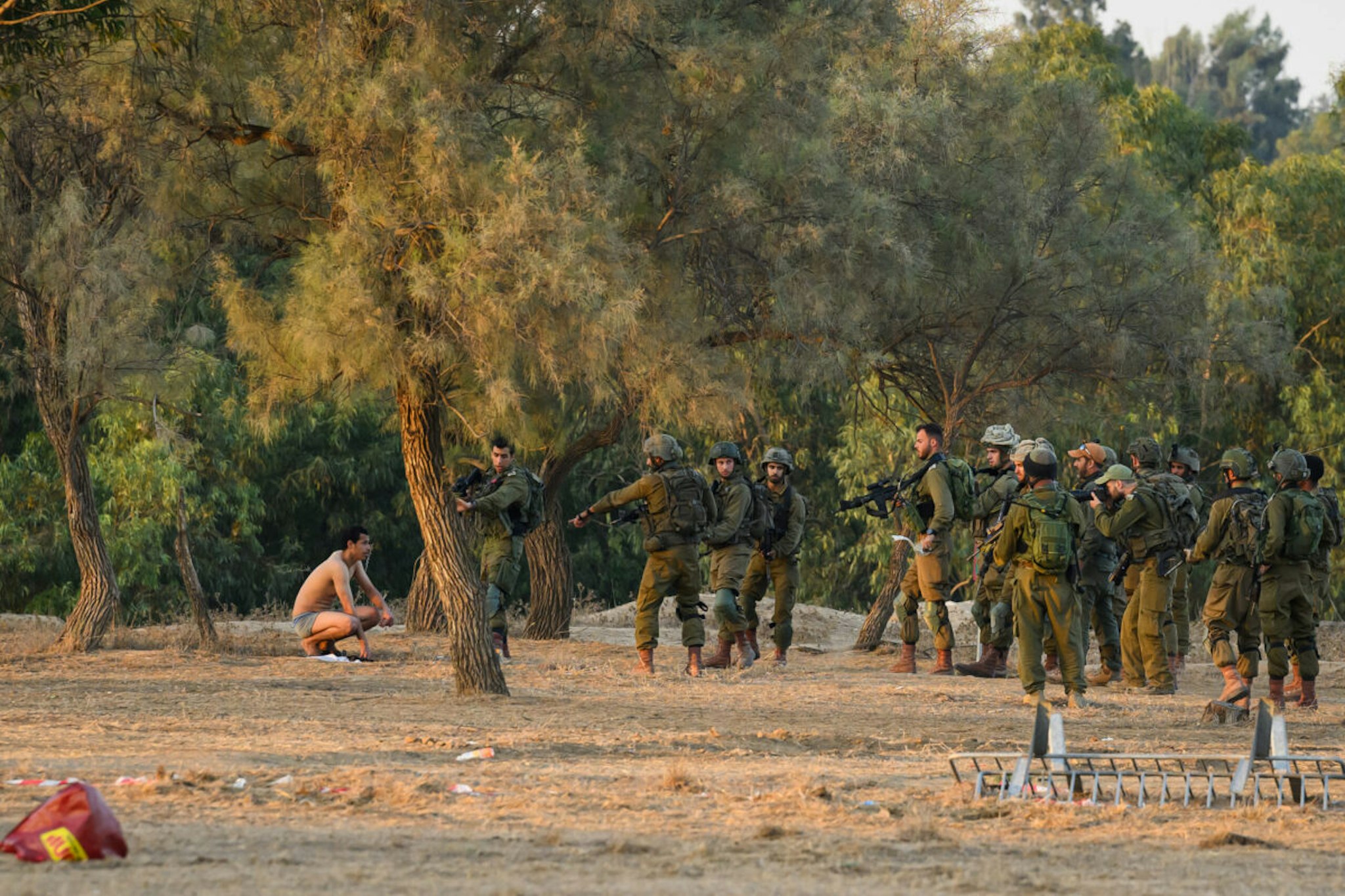 A man is ordered to undress before being arrested by members of the security forces following an incident at the Supernova Music Festival site, five days after hundreds were killed and dozens taken by Hamas militants, near the border with Gaza on October 12, 2023 in Kibbutz Re'im, Israel.