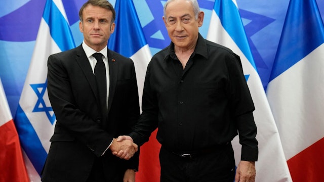 TOPSHOT - Israeli Prime Minister Benjamin Netanyahu (R) greets French President Emmanuel Macron before a meeting in Jerusalem on October 24, 2023. Macron's visit comes more than two weeks after Hamas militants stormed into Israel from the Gaza Strip and killed at least 1,400 people, according to Israeli officials while Israel continues a relentless bombardment of the Gaza Strip and prepares for a ground offensive with more than 5,000 Palestinians, mainly civilians, killed so far across the Palestinian territory, according to the latest toll from the Hamas health ministry in Gaza.