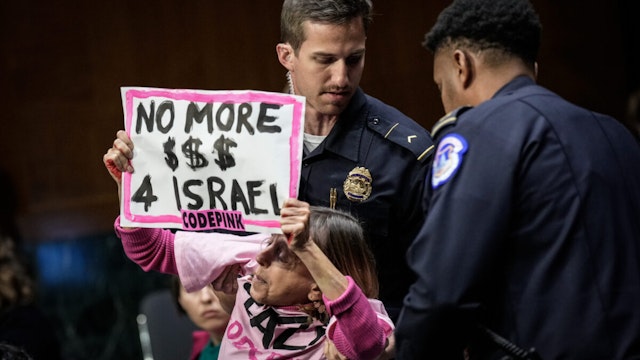 A protestor calling for a ceasefire in Gaza yells as she is escorted out of the room by Capitol Police during a Senate Appropriations Committee hearing with U.S. Secretary of State Antony Blinken and U.S. Secretary of Defense Lloyd Austin on October 31, 2023 in Washington, DC.