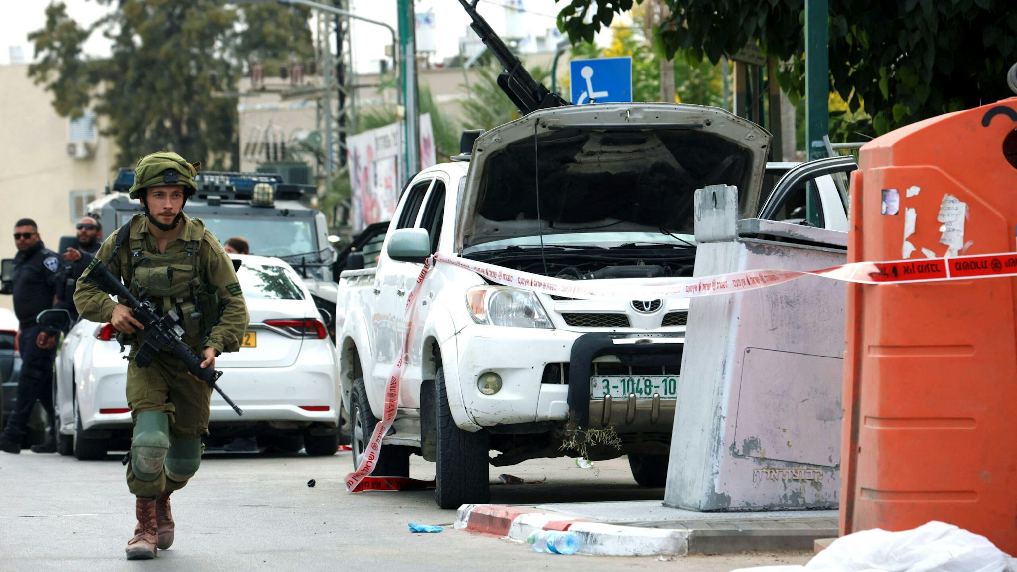 An Israeli soldier stands guard next to a pickup truck mounted with machine gun in the southern city of Sderot on October 7, 2023, after the Palestinian militant group Hamas launched a large-scale surprise attack on Israel. At least 40 people have been killed in Israel during fighting with Palestinian militants on October 7, the Magen David Adom emergency medical services said in a statement.
