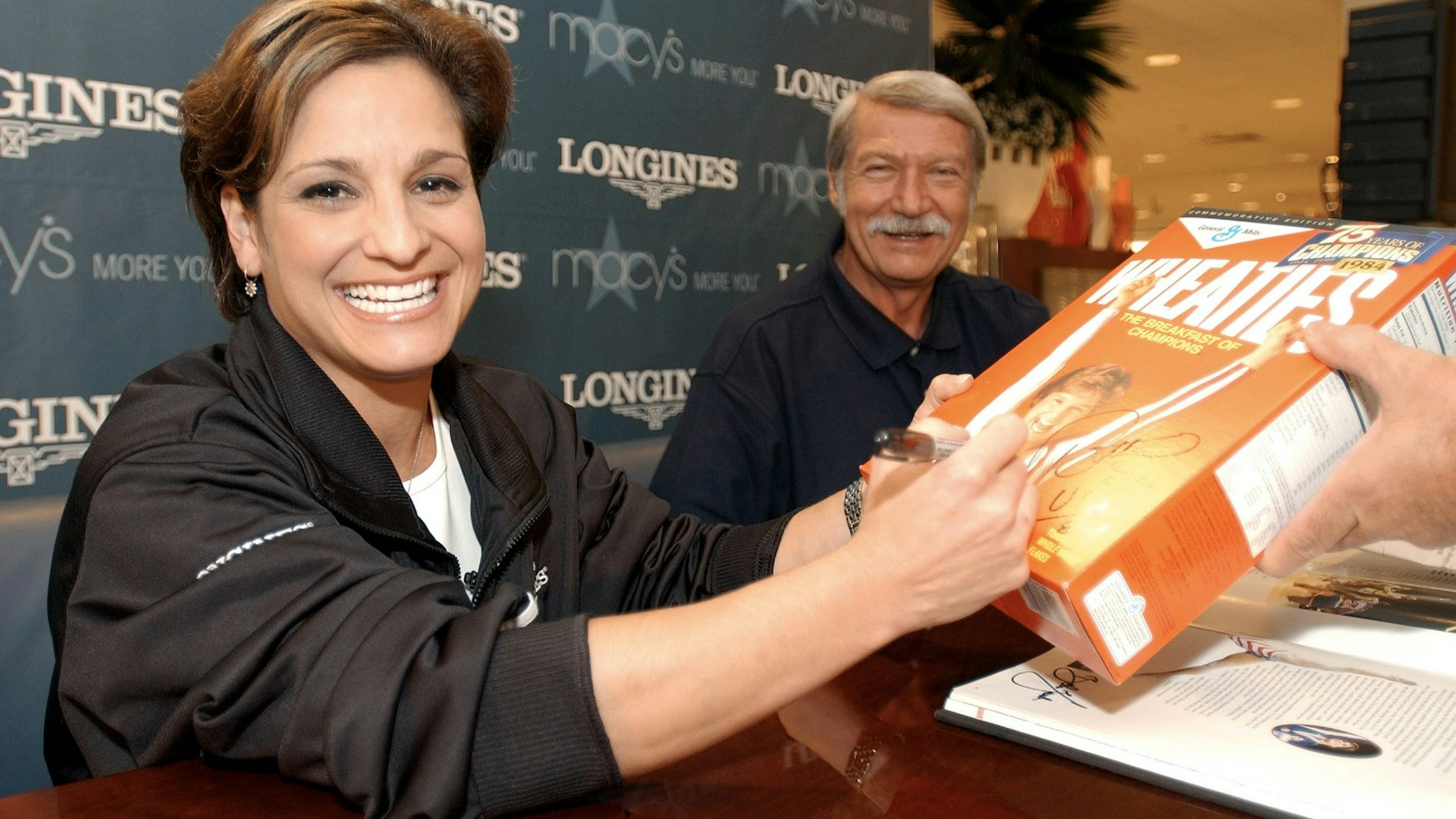 Olympian Mary Lou Retton (left), an official with the "Longines Perfect 10 Moments in Time" joined famed Olympic coach Bela Karolyi signing autographs for fans at Macy's at the South Coast Plaza 7/25/03.