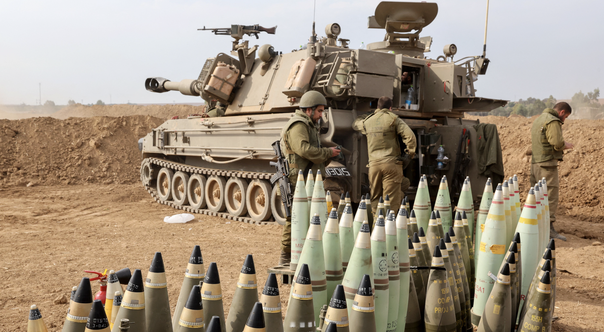 Artillery shells are lined up next to an armoured vehicle as Israeli soldiers take positions near the border with Gaza in southern Israel on October 9, 2023. Stunned by the unprecedented assault on its territory, a grieving Israel has counted over 700 dead and launched a withering barrage of strikes on Gaza that have raised the death toll there to 493 according to Palestinian officials.