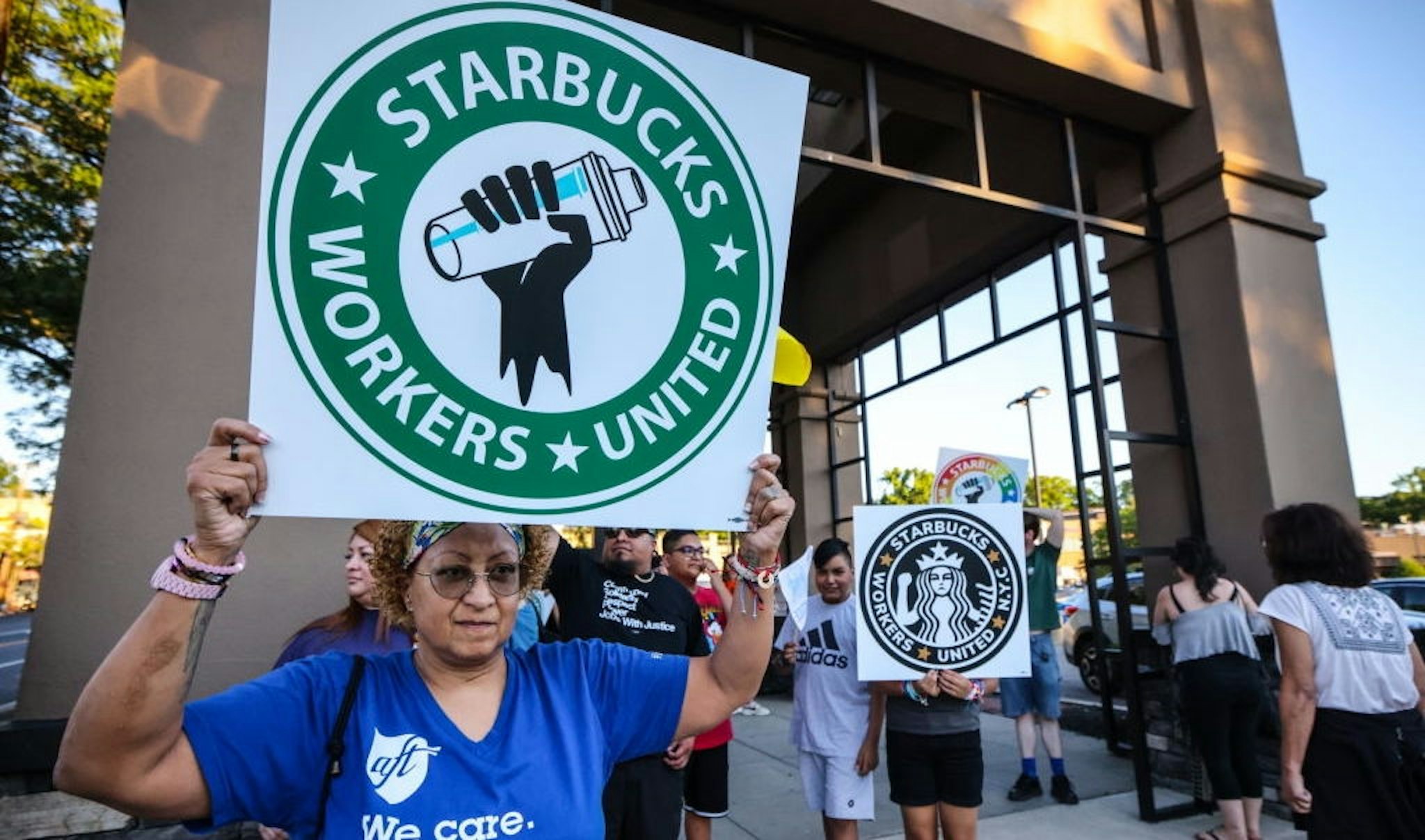 Great Neck, N.Y.: A woman holds up a sign as she joins other protestors in a rally against what they perceive to be union busting tactics, outside a Starbucks in Great Neck, New York, demanding the reinstatement of a former employee on August 15, 2022. (Photo by Thomas A. Ferrara/Newsday RM via Getty Images)
