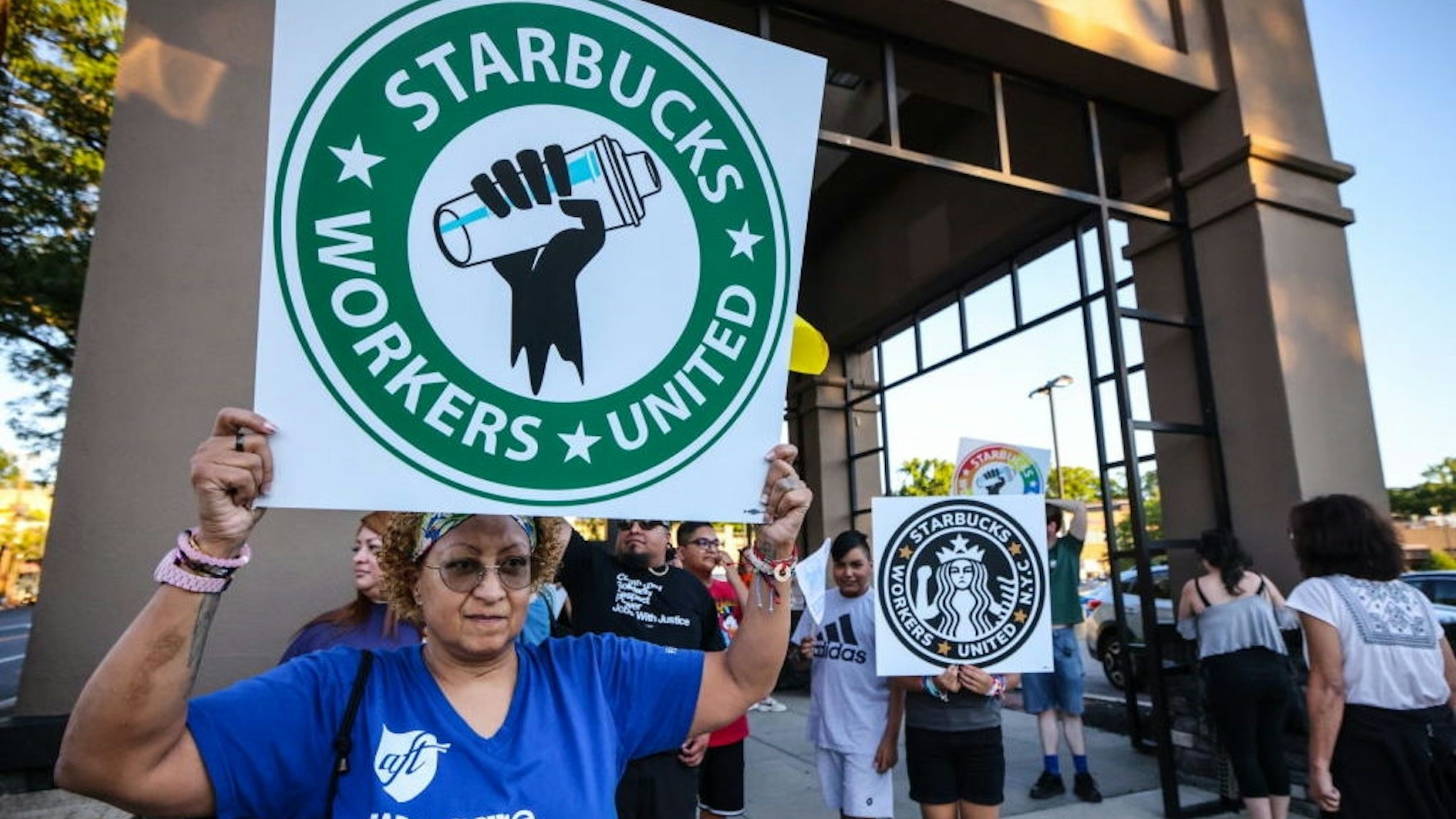 Great Neck, N.Y.: A woman holds up a sign as she joins other protestors in a rally against what they perceive to be union busting tactics, outside a Starbucks in Great Neck, New York, demanding the reinstatement of a former employee on August 15, 2022. (Photo by Thomas A. Ferrara/Newsday RM via Getty Images)