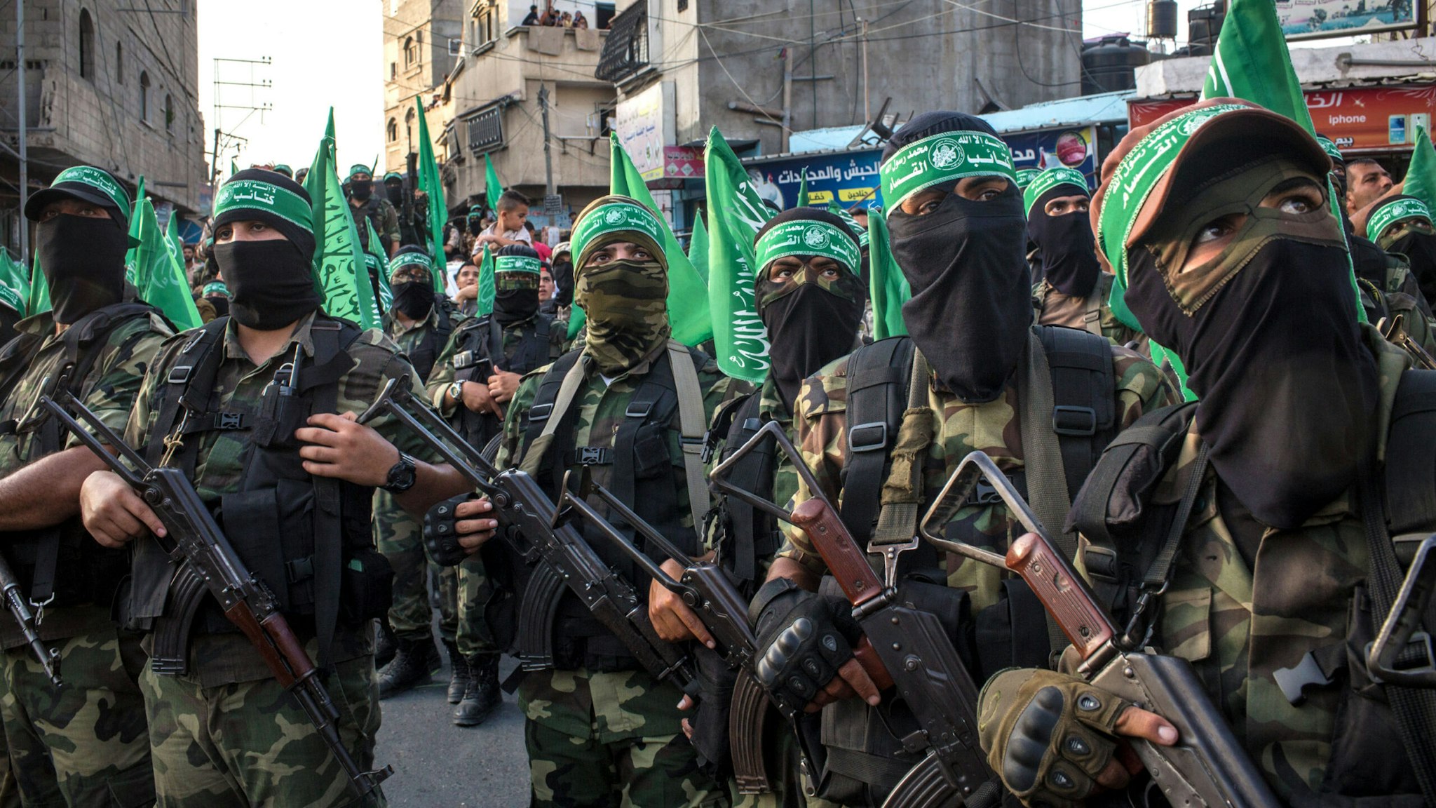 GAZA CITY, GAZA - JULY 20: Palestinian Hamas militants are seen during a military show in the Bani Suheila district on July 20, 2017 in Gaza City, Gaza. For the past ten years Gaza residents have lived with constant power shortages, in recent years these cuts have worsened, with supply of regular power limited to four hours a day. On June 11, 2017 Israel announced a new round of cuts at the request of the Palestinian authorities and the decision was seen as an attempt by President Mahmoud Abbas to pressure Gaza's Hamas leadership. Prior to the new cuts Gaza received 150 megawatts per day, far below it's requirements of 450 megawatts. In April, Gaza's sole power station which supplied 60 megawatts shut down, after running out of fuel, the three lines from Egypt, which provided 27 megawatts are rarely operational, leaving Gaza reliant on the 125 megawatts supplied by Israel's power plant. The new cuts now restrict electricity to three hours a day severely effecting hospital patients with chronic conditions and babies on life support. During blackout hours residents use private generators, solar panels and battery operated light sources to live. June 2017 also marked ten years since Israel began a land, sea and air blockade over Gaza. Under the blockade, movement of people and goods is restricted and exports and imports of raw materials have been banned. The restrictions have virtually cut off access for Gaza's two million residents to the outside world and unemployment rates have skyrocketed forcing many people into poverty and leaving approximately 80% of the population dependent on humanitarian aid.