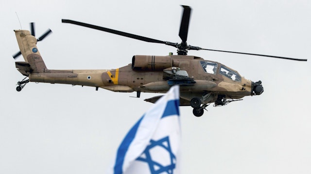 An Israeli AH-64 Apache longbow helicopter performs during an air show at the graduation ceremony of Israeli air force pilots at the Hatzerim Israeli Air Force base in the Negev desert, near the southern Israeli city of Beer Sheva, on December 27, 2017.