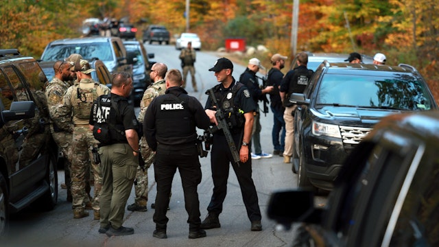 BOWDOIN, MAINE - OCTOBER 26: Law enforcement officials gather in the road leading to the home of the suspect being sought in connection with two mass shootings on October 26, 2023 in Bowdoin, Maine. Police are searching for U.S. Army Reservist Robert Card, 40, who is wanted in the shooting deaths of 18 people at a bowling alley and a bar last night in nearby Lewiston. At least 13 others were wounded in the rampage.
