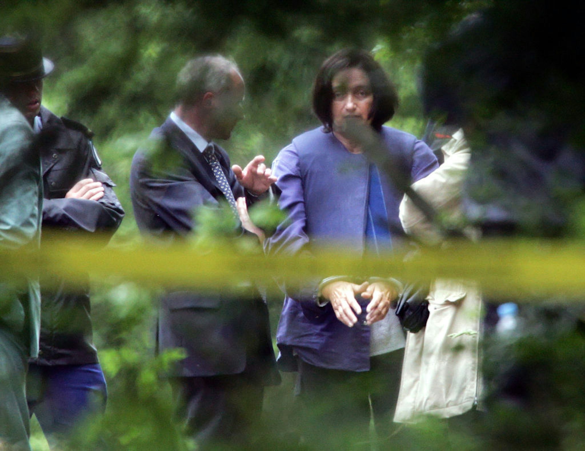 Monique Olivier, the wife of Frenchman Michel Fourniret who confessed to burying two of his nine young victims, accompanies police at the scene where investigators are digging in the grounds of the chateau 'Le Sautou' near Donchery, northern France, July 3, 2004 to recover the remains of the victims.