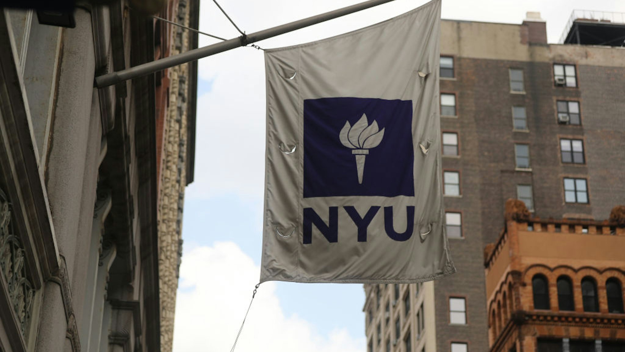 NEW YORK, NEW YORK - AUGUST 25: A New York University (NYU) flag flies outside a Covid-19 test tent outside of the NYU business school on August 25, 2020 in New York City. All students arriving back to the campus are required to get tested for the virus upon arrival and must be tested again seven to 10 days later. Classes are set to begin on September 2. (Photo by Spencer Platt/Getty Images)