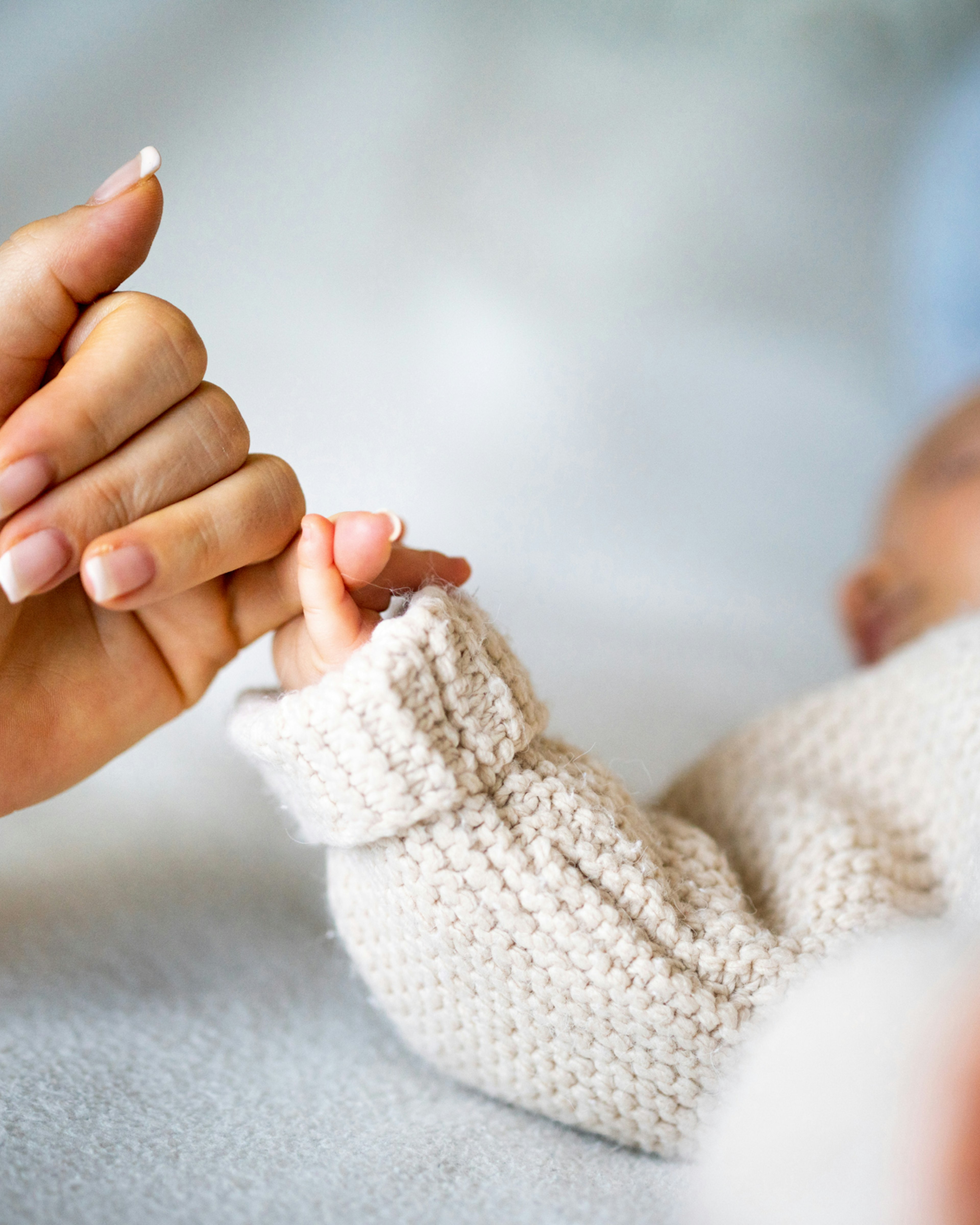 Close-up of mother's hand holding newborn baby's hand. StockPlanets. Getty Images.