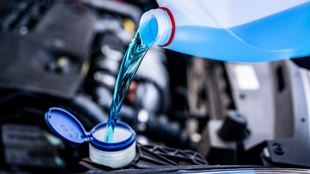 Pouring antifreeze. Filling a windshield washer tank with an antifreeze in winter cold weather. - stock photo