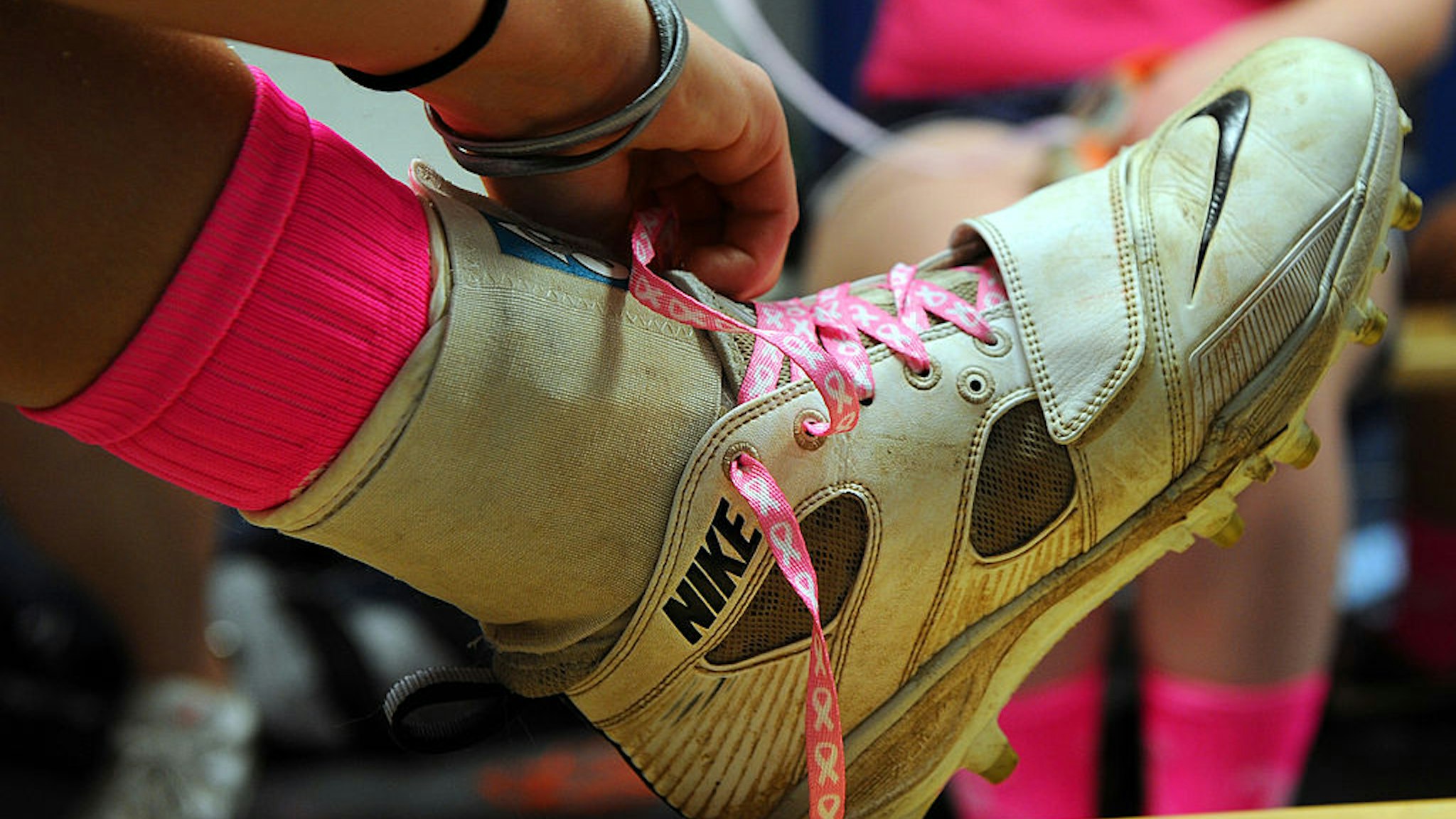 ASHBURN, VA- APRIL 4: A Stone Bridge girls' varsity lacrosse player relaces her cleats before the start of their Liberty District Tournament game against South Lakes on Friday, May 4, 2012. Thirty girls' teams in Northern Virginia wore at least pink shoelaces, pink ribbons, and pink sports wrap as part of the Virginia Northern Region Girls Lacrosse "VHSL Tournament For A Cure". (Photo by Toni L. Sandys/The Washington Post via Getty Images)