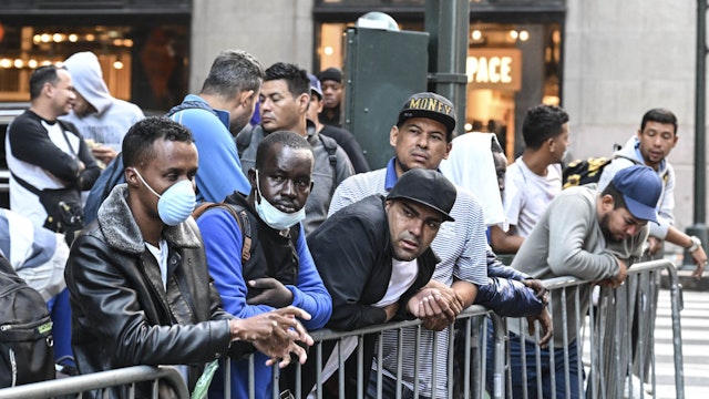 NEW YORK, US - AUGUST 02: Migrants line up outside Roosevelt Hotel while waiting for placement inside a shelter as asylum seekers camp outside the hotel as the Manhattan relief center is at full capacity in New York, United States on August 02, 2023. Since last spring, New York City has experienced a staggering influx of tens of thousands of asylum seekers. In response to the surge in migration, the city has established more than 160 sites to accommodate and assist these individuals. New York Mayor Eric Adams stated in early June that the city takes on important responsibilities by providing shelter, food, clothing and other essential services to incoming asylum seekers. (Photo by Fatih Aktas/Anadolu Agency via Getty Images)