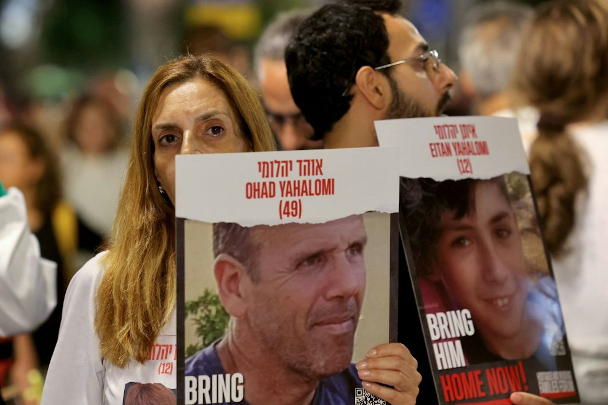 People carry posters with the images of the Ohad, 49, and Eitan Yahalomi, 12, on November 11, 2023, during a demonstration in Tel Aviv calling for the release of Israeli hostages taken by Palestinian militants in the October 7 attack, and currently held in the Gaza Strip, amid the ongoing battles between Israel and the militant group Hamas. (Photo by AHMAD GHARABLI / AFP) (Photo by AHMAD GHARABLI/AFP via Getty Images)