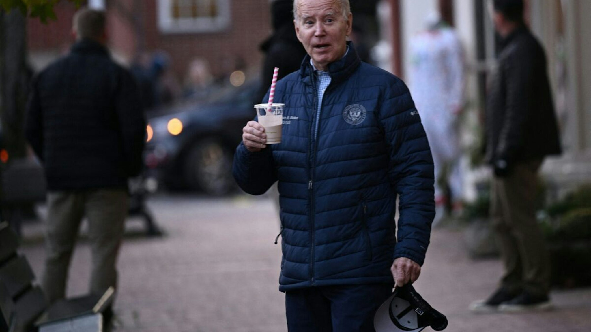 US President Joe Biden carries a drink as he visits local shops with relatives in Nantucket, Massachusetts, on November 25, 2023.