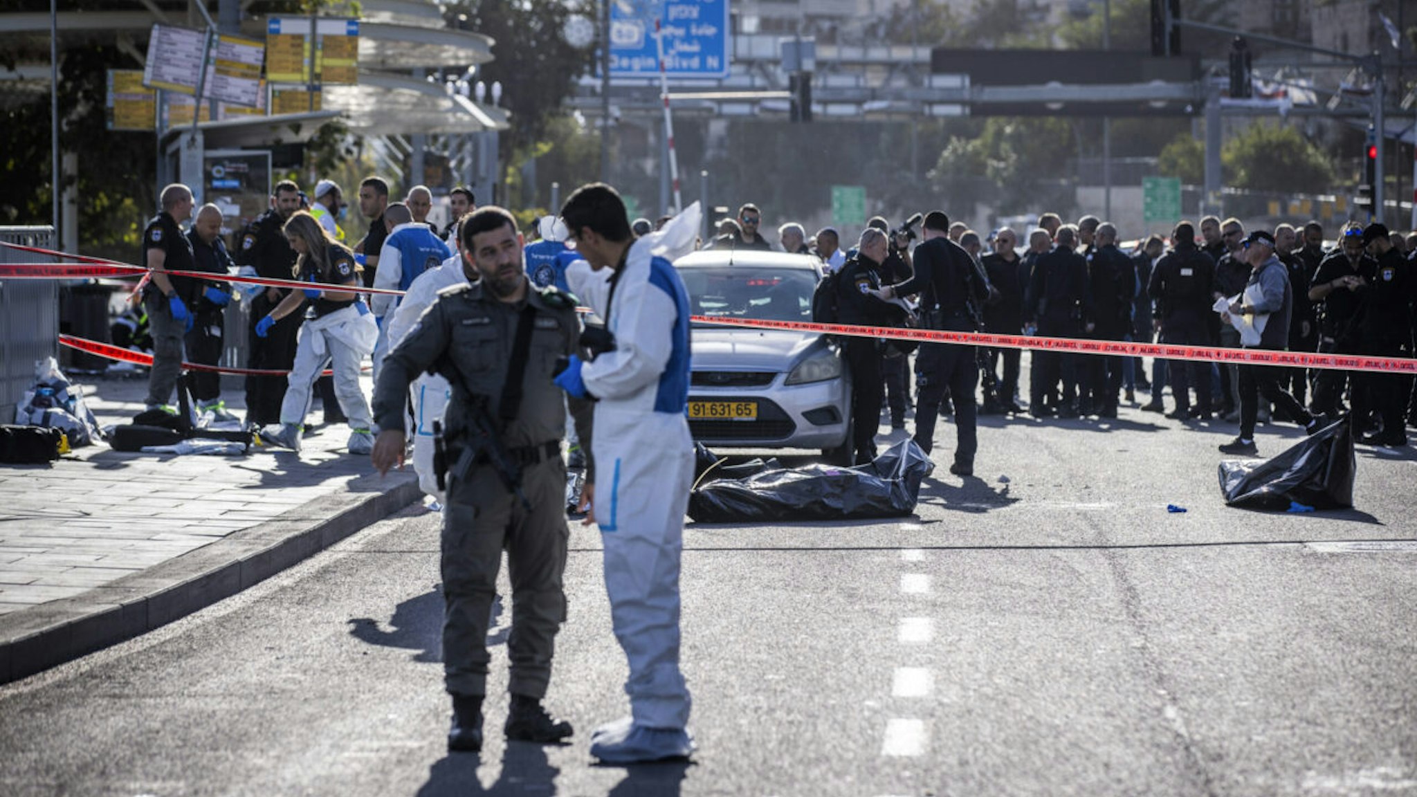 30 November 2023, Israel, Jerusalem: ZAKA International Rescue Unit members and Israeli police officers work at the scene of a shooting attack involving two Palestinian attackers who opened fire on people waiting at a bus stop, killing three people and injuring at least 16 others.