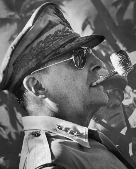 Headshot of American military leader General Douglas MacArthur (1880 - 1964), wearing a military uniform and sunglasses, smoking a corn cob pipe, Leyte Island, Philippines. MacArthur is surveying the beachhead after American forces waded ashore to liberate the Philippines from Japan during World War II. (Photo by Archive Photos/Getty Images)