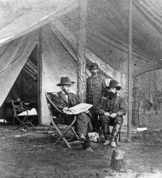 1864: Union General Ulysses S. Grant (left) sitting with two men in front of a tent at camp during the U.S. Civil War. (Photo by Hulton Archive/Getty Images)