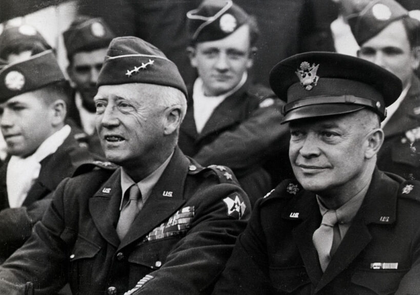 Dwight D. Eisenhower with General George S. Patton. Other military men are in the background. Getty Images.