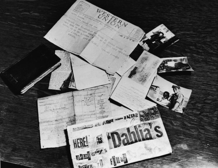 Evidence concerning the murder of American aspiring actress and murder victim Elizabeth Short (1924 - 1947), known as the 'Black Dahlia,' is strown across a table at the Los Angeles District Attorney's office, Los Angeles, California, 1947. On the table is a black address book, a newspaper clipping about the death of Short's supposed fiance and American Amy Major Matthew M. Gordon Jr., Short's birth certificate, a business card, a threatening letter assembled from newspaper lettering, a baggage check from a Greyhound bus depot, a Western Union telegram, and several photographs of Short. (Photo by INTERNATIONAL NEWS PHOTO/Getty Images)