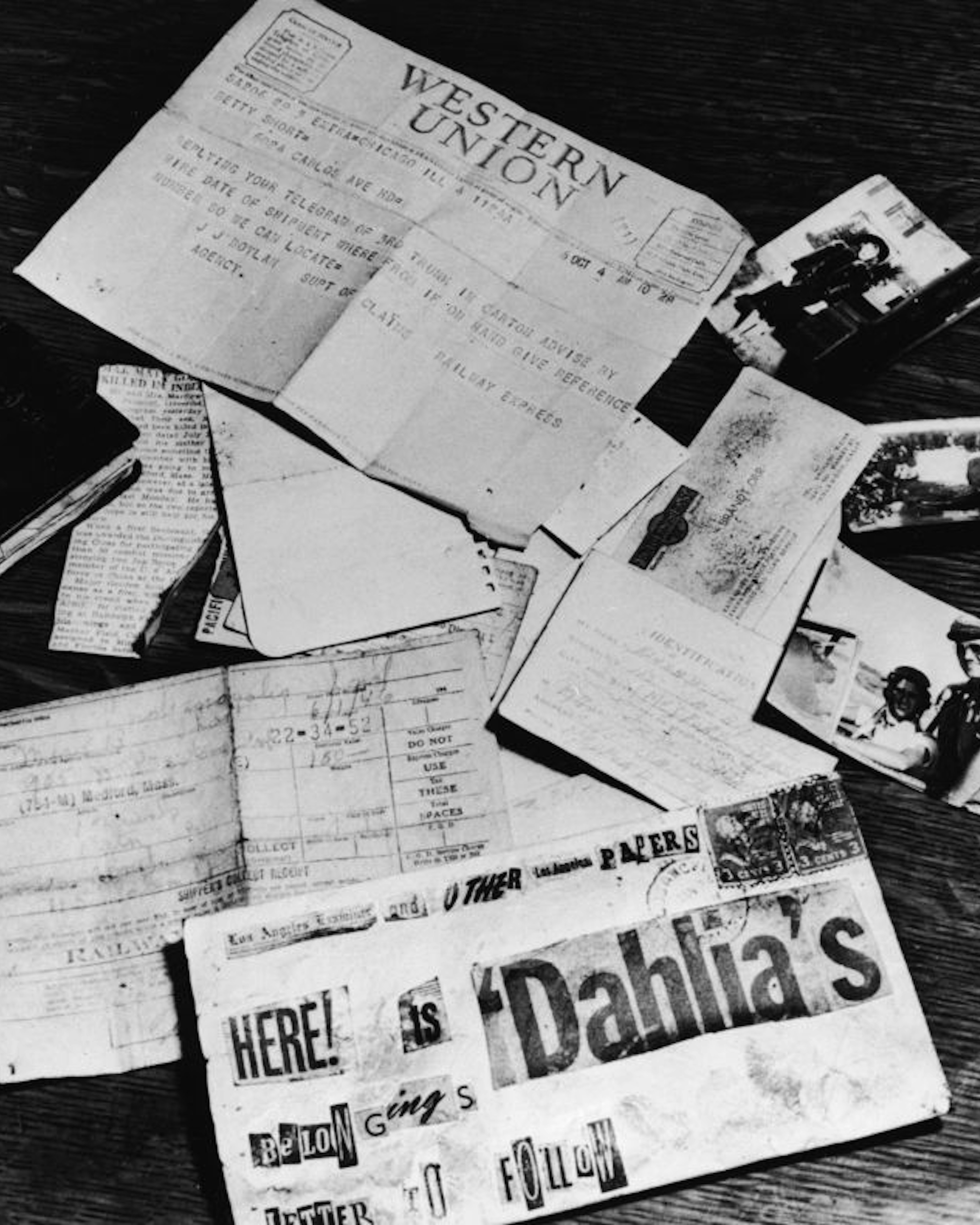 Evidence concerning the murder of American aspiring actress and murder victim Elizabeth Short (1924 - 1947), known as the 'Black Dahlia,' is strown across a table at the Los Angeles District Attorney's office, Los Angeles, California, 1947. On the table is a black address book, a newspaper clipping about the death of Short's supposed fiance and American Amy Major Matthew M. Gordon Jr., Short's birth certificate, a business card, a threatening letter assembled from newspaper lettering, a baggage check from a Greyhound bus depot, a Western Union telegram, and several photographs of Short. (Photo by INTERNATIONAL NEWS PHOTO/Getty Images)