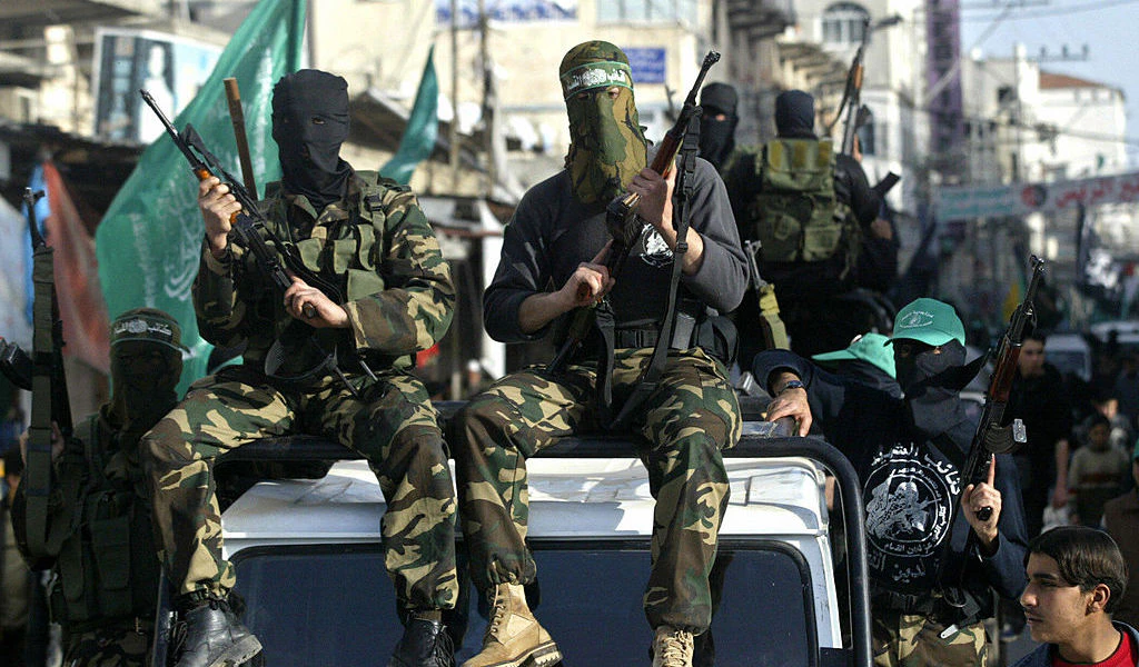 GAZA CITY, : Palestinian militants from the Ezz al-Din al-Qassam Brigades, the militarily wing of the Hamas movement, take part in the funeral of one of its leading members Abed Abu Daf, killed in an accidental explosion during a training exercise, in Gaza city, 24 February 2006. AFP PHOTO/MAHMUD HAMS (Photo credit should read MAHMUD HAMS/AFP via Getty Images)