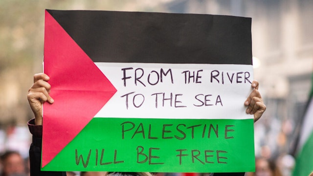 A woman holds a banner reading 'From the River to the sea, Palestine wil be Free' during a Pro-Palestina protest in Buenos Arires, Argentina on May 17, 2021. Around 3000 people protesting to show solidarity with Palestina after the conflict between Israel and Palestina escalated this week.