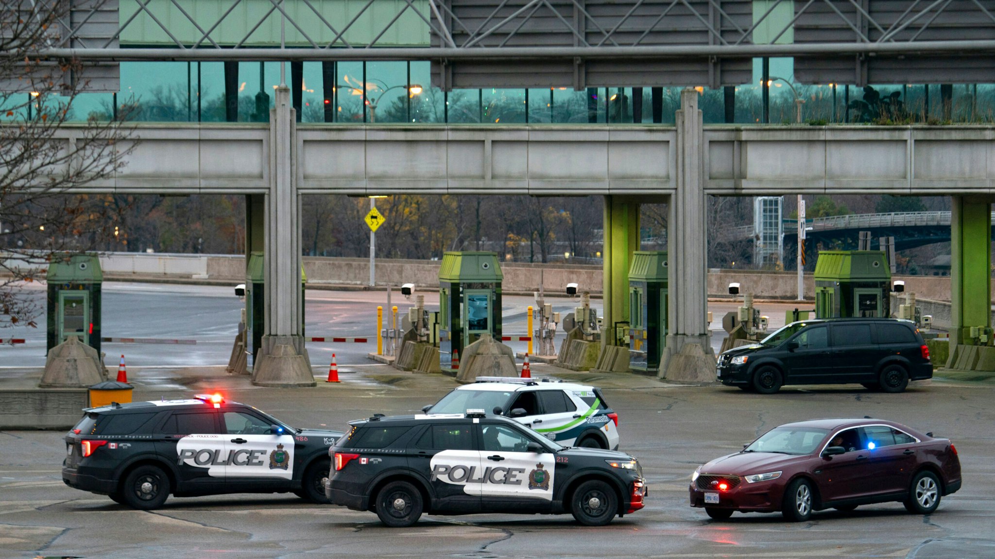 Canadian police cars are seen near the Rainbow Bridge border crossing into the US in Niagara Falls, Ontario, after a car exploded at a US-Canada checkpoint on November 22, 2023. US terrorism investigators deployed Wednesday after a car erupted into a fireball at a US-Canada checkpoint, triggering border closures on one of the busiest travel days in the American holiday calendar. Two people were killed in the blast, according to US media citing authorities, although their identi