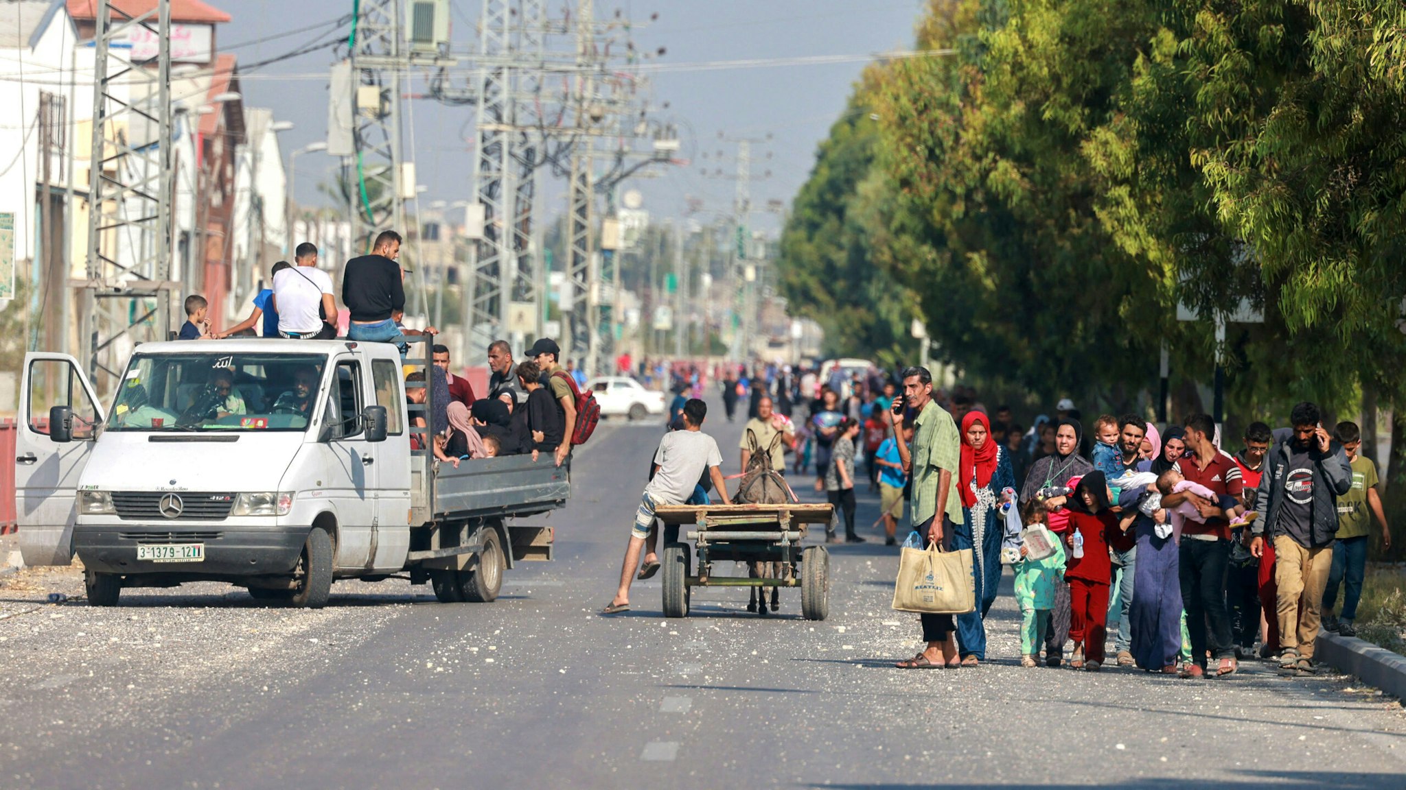 People carrying some of their belongings reach the central Gaza Strip via the Salah al-Din road on their way to the southern part of the Palestinian enclave on November 5, 2023. Leaflets dropped by the Israeli army on November 5, urged Gaza City residents to evacuate south between 10 am (0800 GMT) and 2 pm (1200 GMT), a day after a US official said at least 350,000 civilians remained in and around the city that is now an urban war zone.