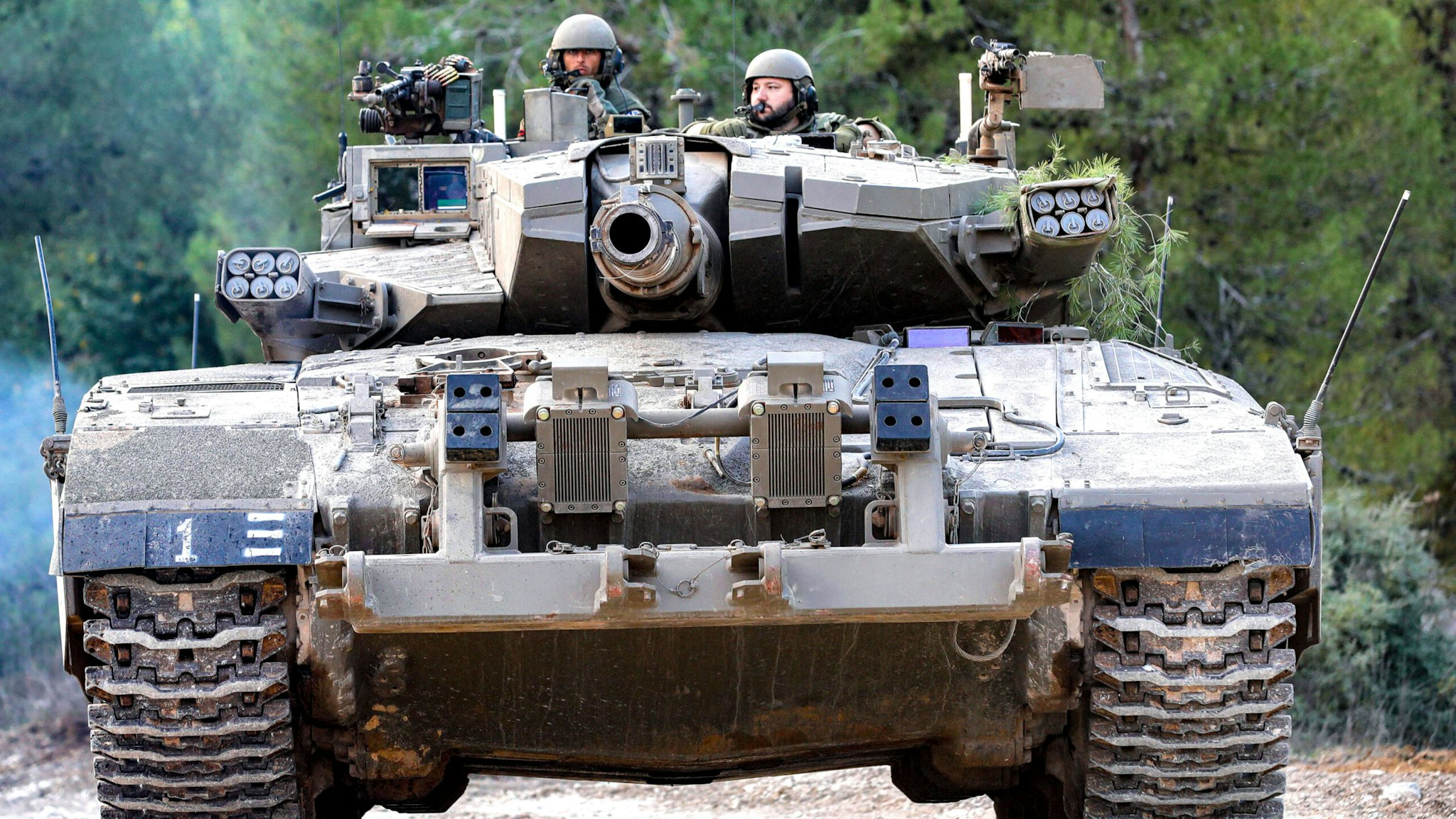 Israeli army soldiers sit in the turret of a battle tank moving at a position in the upper Galilee region of northern Israel near the border with Lebanon on November 1, 2023 amid increasing cross-border tensions between Hezbollah and Israel as fighting continues in the south with Hamas militants in the Gaza Strip.