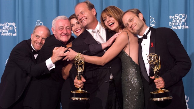 Emmy-winners, Actors Kelsey Grammer (center) and David Hyde Pierce (R) are joined by fellow 'Frasier' cast members actors Jane Leeves (2nd R), Peri Gilpin, John Mahoney (2nd L) and James Burrows (L) for a group-hug backstage"nat the 50th Annual Emmy Awards, on September 13, 1998 in Los Angeles, California.
