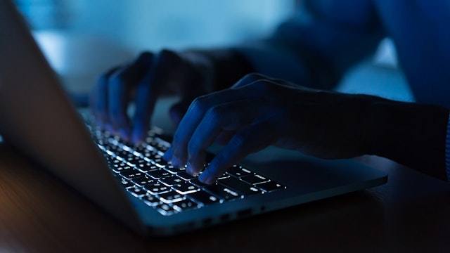 close up programmer man hand typing on keyboard laptop for register data system or access password at dark operation room , cyber security concept.