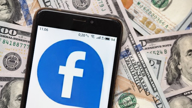 UKRAINE - 2020/09/04: In this photo illustration a Facebook logo seen displayed on a smartphone with 100 dollar bills in the background. (Photo Illustration by Igor Golovniov/SOPA Images/LightRocket via Getty Images)