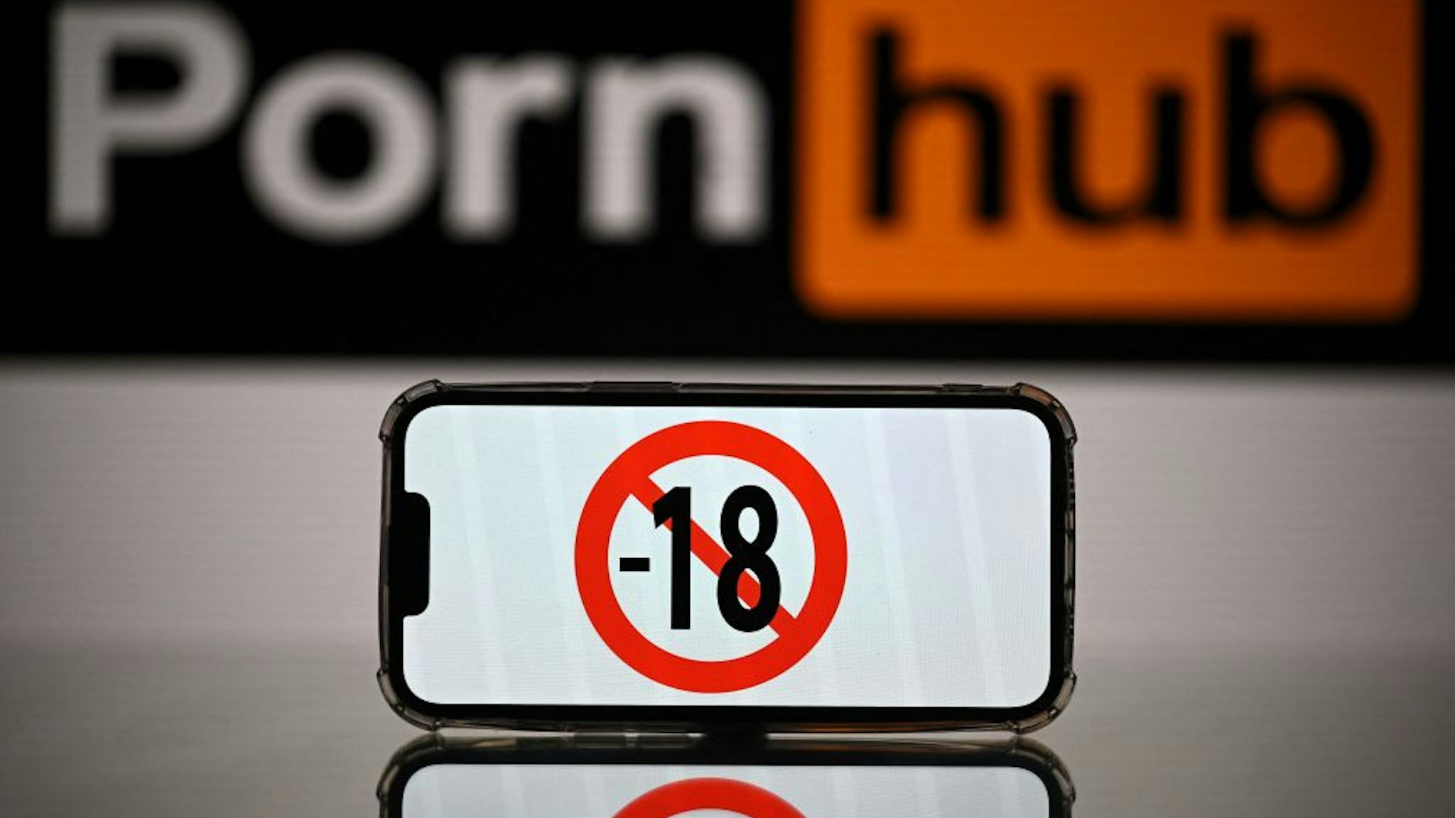 This photograph taken on May 24, 2022 in Toulouse shows screens displaying a minor child sign and the logo of the pornographic site Pornhub. - The judicial examination of Arcom request against porn sites has been postponed to one month, on May 24, 2022. Arcom media regulator requests five pornographic sites to be blocked as they are not preventing the exposure of minors to their content, and French telecom operators to block access to the pornographic sites. (Photo by Lionel BONAVENTURE / AFP)