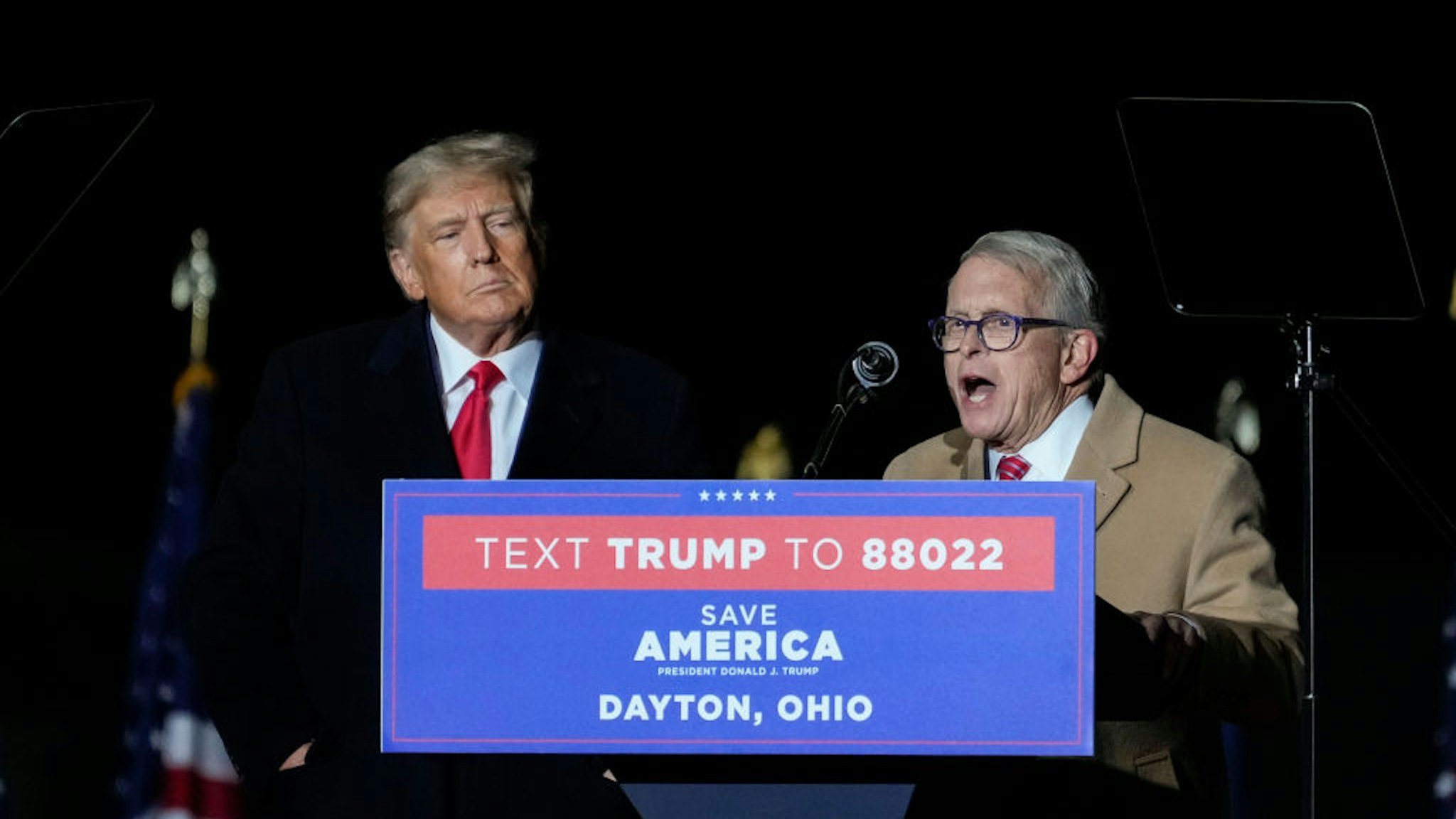 VANDALIA, OHIO - NOVEMBER 07: Former U.S. President Donald Trump (L) looks on as Ohio Gov. Mike DeWine speaks at a rally for Ohio Republicans at the Dayton International Airport on November 7, 2022 in Vandalia, Ohio. Trump is campaigning for Republican candidates, including U.S. Senate candidate JD Vance, who faces U.S. Rep. Tim Ryan (D-OH) in tomorrow's general election.