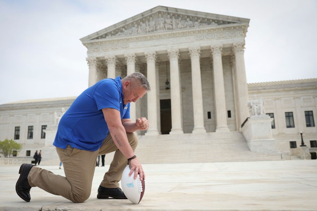 WASHINGTON, DC - APRIL 25: Former Bremerton High School assistant football coach Joe Kennedy takes a knee in front of the U.S. Supreme Court after his legal case, Kennedy vs. Bremerton School District, was argued before the court on April 25, 2022 in Washington, DC. Kennedy was terminated from his job by Bremerton public school officials in 2015 after refusing to stop his on-field prayers after football games. (Photo by Win McNamee/Getty Images)