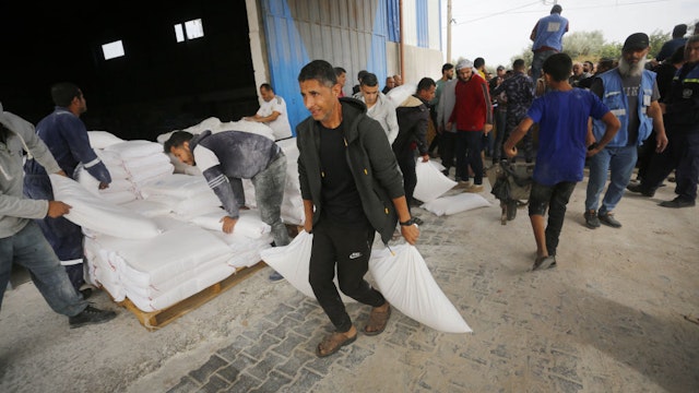 DEIR AL BALAH, GAZA - NOV 25: Flour is being distributed in Nuseirat refugee camp by the UN agency for Palestinian refugees, or UNRWA to Gazans who had difficulty finding bread due to Israeli attacks, on November 25, 2023 in Deir Al Balah, Gaza. (Photo by Ashraf Amra/Anadolu via Getty Images)