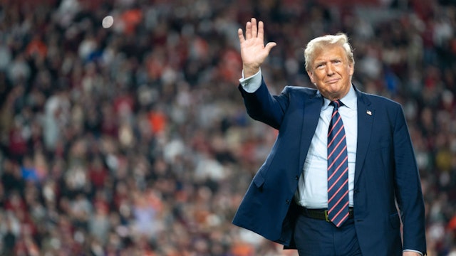 COLUMBIA, SOUTH CAROLINA - NOVEMBER 25: Former U.S. President Donald Trump waves to the crowd on the field during halftime in the Palmetto Bowl between Clemson and South Carolina at Williams Brice Stadium on November 25, 2023 in Columbia, South Carolina. Trump attended the rivalry game in a key early-voting state as he campaigns ahead of next year’s Republican presidential primary. (Photo by Sean Rayford/Getty Images)