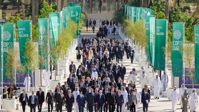 DUBAI, UNITED ARAB EMIRATES - DECEMBER 1: In this handout image provided by COP28, world leaders walk down Al Wasl avenue following a family photo during day one of the high-level segment of the UNFCCC COP28 Climate Conference at Expo City Dubai on December 1, 2023 in Dubai, United Arab Emirates. The COP28, which is running from November 30 through December 12, brings together stakeholders, including international heads of state and other leaders, scientists, environmentalists, indigenous peoples representatives, activists and others to discuss and agree on the implementation of global measures towards mitigating the effects of climate change. (Photo by Neville Hopwood/COP28 via Getty Images)