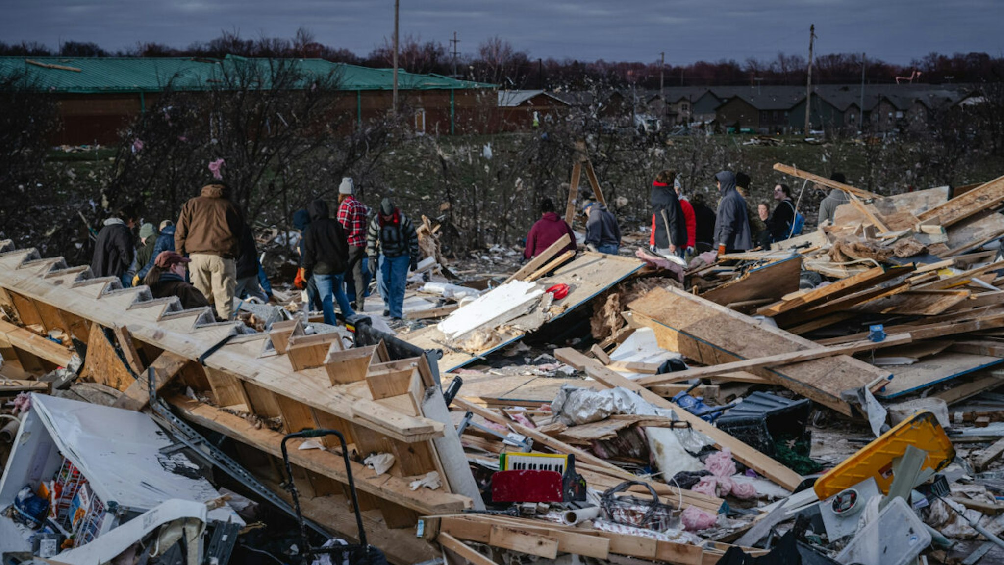 CLARKSVILLE, TENNESSEE - DECEMBER 10: Residents and visitors work to clear debris in search of pets and belongings of a destroyed home in the aftermath of a tornado on December 10, 2023 in Clarksville, Tennessee. Multiple long-track tornadoes were reported in northwest Tennessee on December 9th causing multiple deaths and injuries and widespread damage.