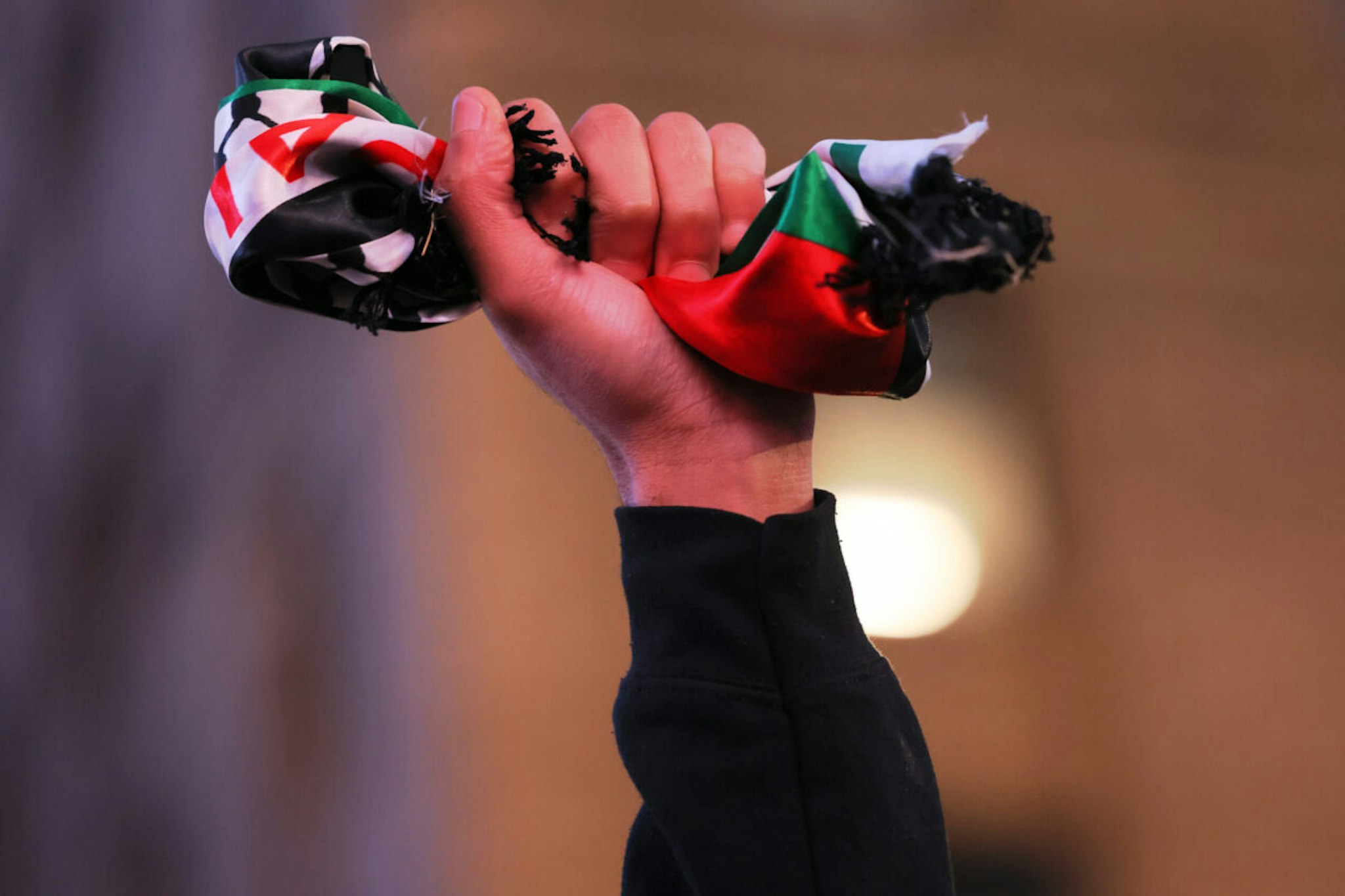 NEW YORK, NEW YORK - DECEMBER 18: A person makes a fist with a Palestinian flag as pro-Palestine activist march and participate in a Global Strike for Gaza on December 18, 2023 in New York City, New York. Activists gathered at Grand Central Station before marching as they continued to demand a ceasefire in Gaza. The protest convened just as the UN Security Council canceled an upcoming vote calling for a cessation of hostilities in Gaza as they try to change the language of the resolution to meet the US objections to the wording of the draft resolution saying they cannot support a “cessation of hostilities," but would agree to a call for a “suspension of hostilities."
