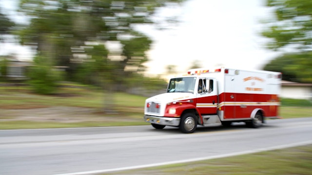 A panning motion blur of an ambulance speeding towards an emergency.
