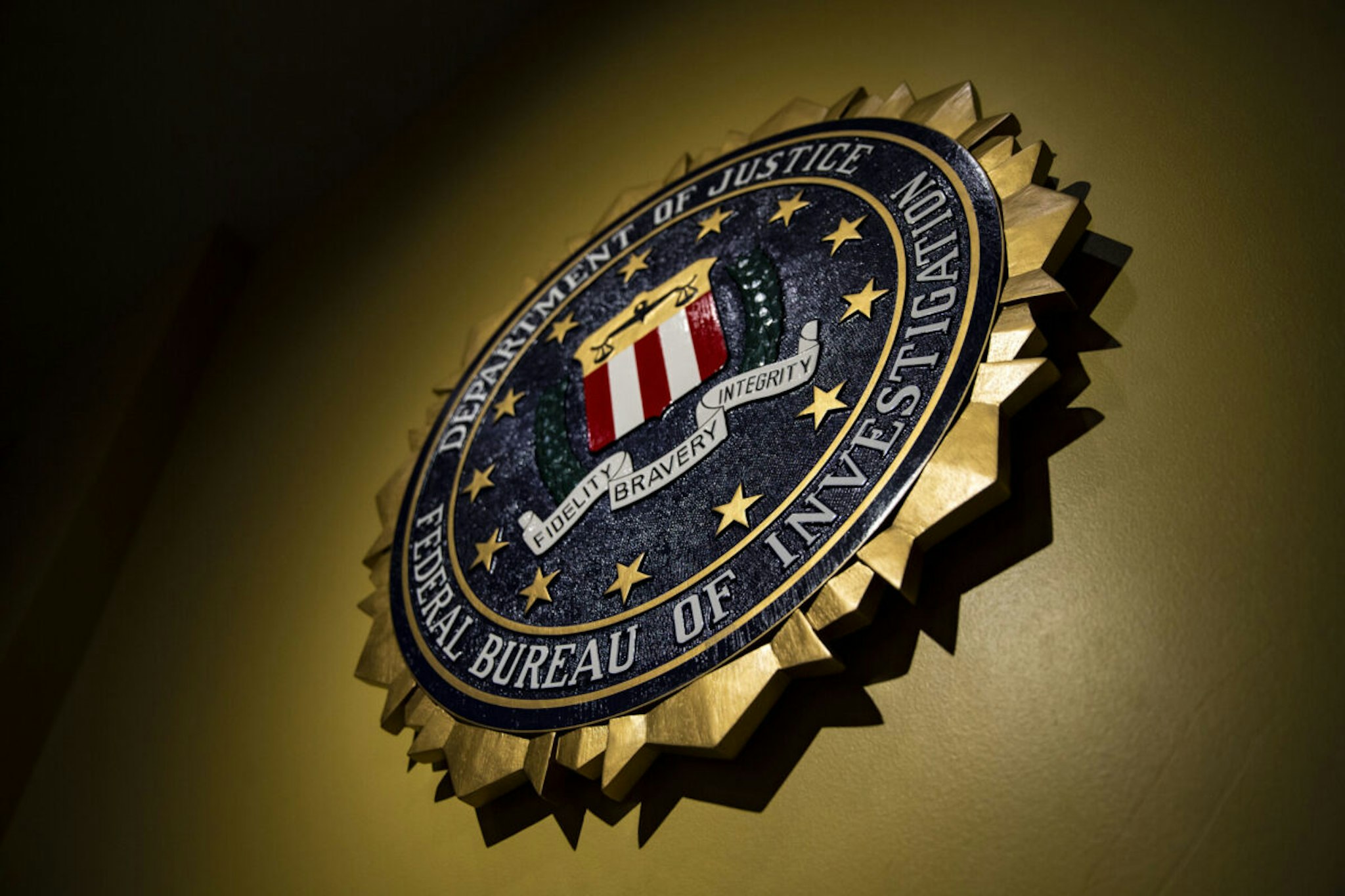 The seal of the Federal Bureau of Investigation (FBI) hangs on a wall before a news conference at the FBI headquarters in Washington, D.C., U.S., on Thursday, June 14, 2018. Former FBI Director James Comey was "insubordinate" in handling the probe into Hillary Clinton, damaging the bureau and the Justice Department's image of impartiality even though he wasn't motivated by politics, the department's watchdog said today.