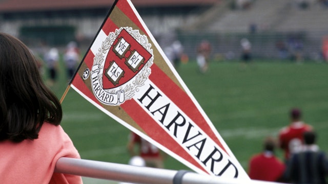 Harvard students and alumnae attend a Harvard football game.