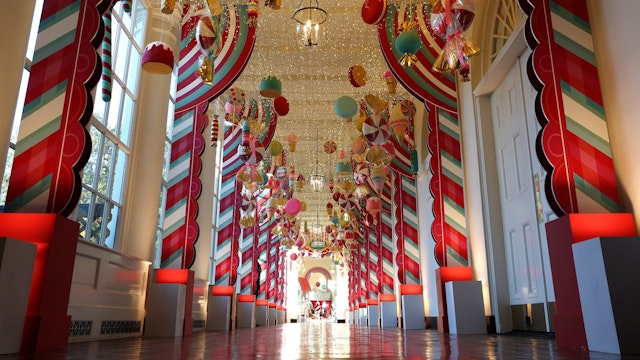 Candy-themed ornaments hang from the ceiling of the hallway between the East Wing and the Residence during a media preview of the holiday decorations at the White House November 27, 2023 in Washington, DC.