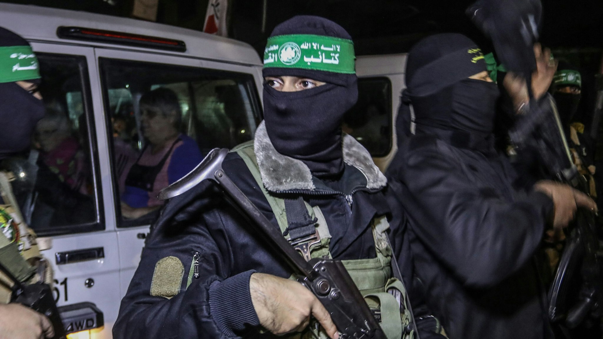 28 November 2023, Palestinian Territories, Rafah: Hamas and Islamic Jihad fighters hand over newly released hostages to the Red Cross in Rafah, as part of a hostages-prisoners swap deal between Hamas and Israel.