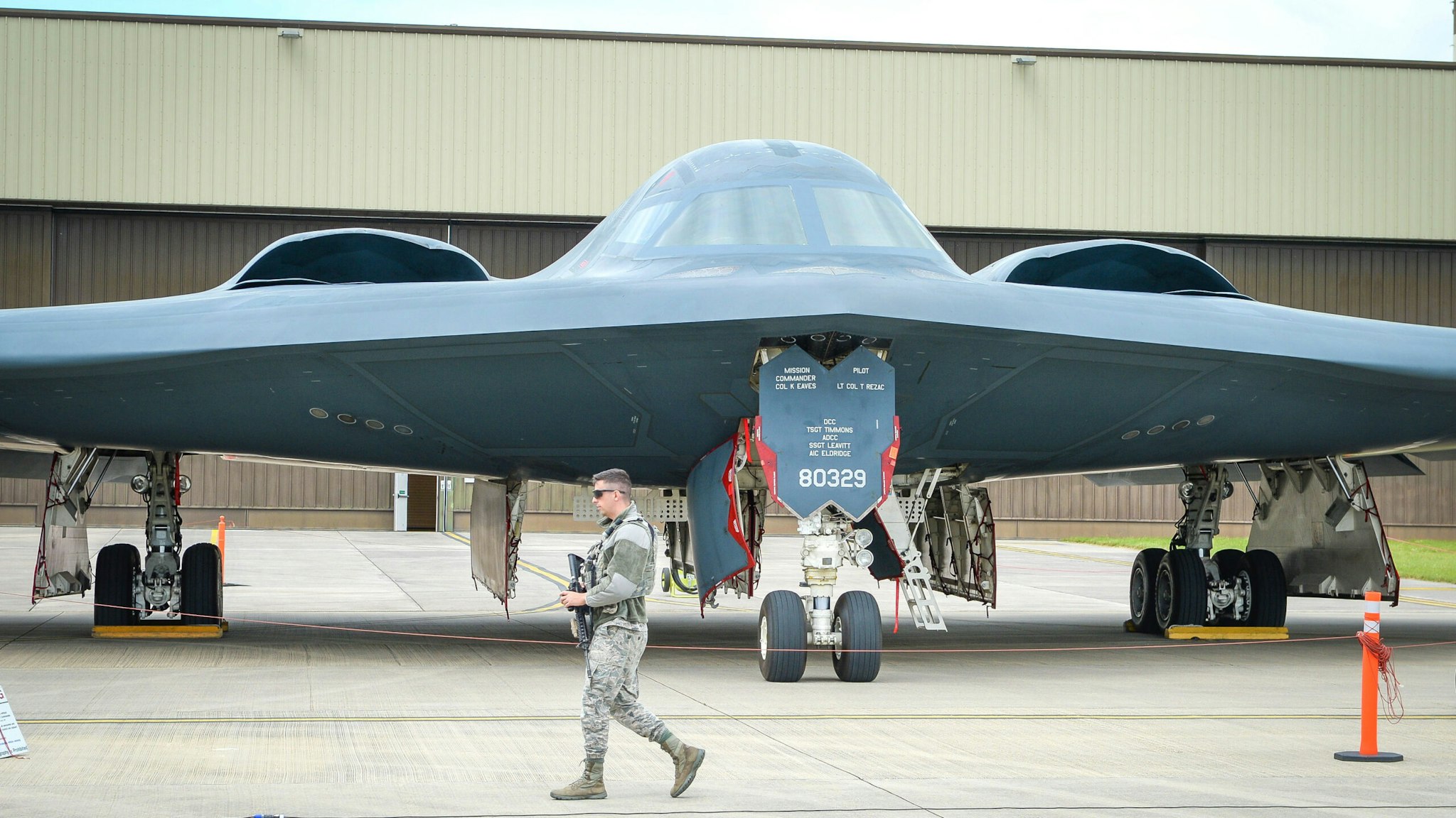 An armed guards patrols the perimeter of a USAF B-2 Spirit bomber at RAF Fairford.