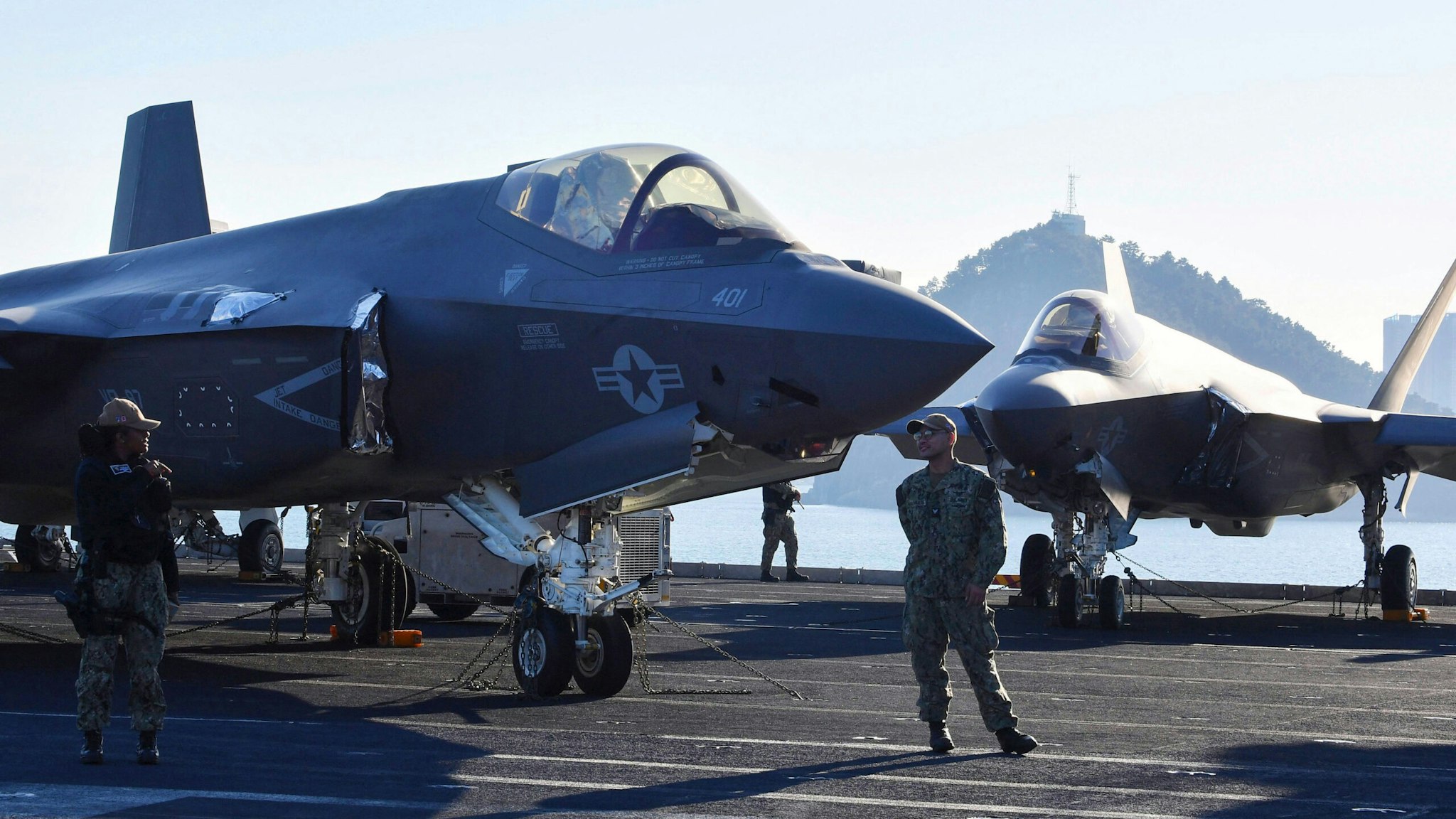 US Navy personnel stand guard in front of F-35C Lightning II on the flight deck aboard the USS Carl Vinson, a US nuclear-powered aircraft carrier, during its port visit at a South Korean naval base in the southeastern port city of Busan on November 22, 2023.
