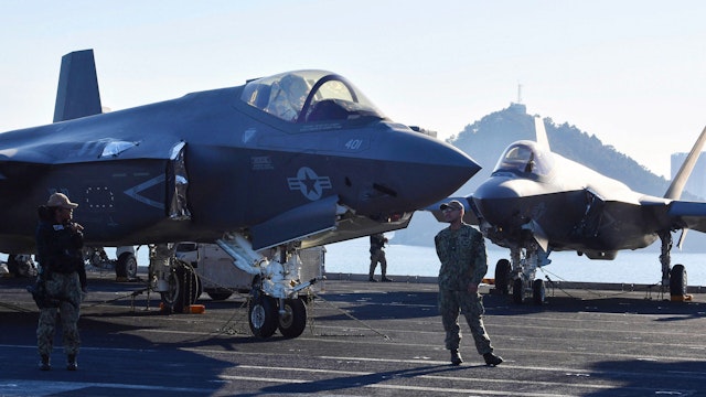 US Navy personnel stand guard in front of F-35C Lightning II on the flight deck aboard the USS Carl Vinson, a US nuclear-powered aircraft carrier, during its port visit at a South Korean naval base in the southeastern port city of Busan on November 22, 2023.