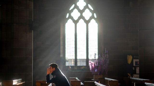 BIRMINGHAM, ENGLAND - DECEMBER 24: A man prays in a church as shoppers make their last minute purchases on Christmas Eve on December 24, 2018 in Birmingham, England. Financial management consultancy Deloitte has predicted larger than normal discounts for boxing day sales as retailers aim to recuperate sales after a weak lead up to Chrismas. (Photo by Christopher Furlong/Getty Images)